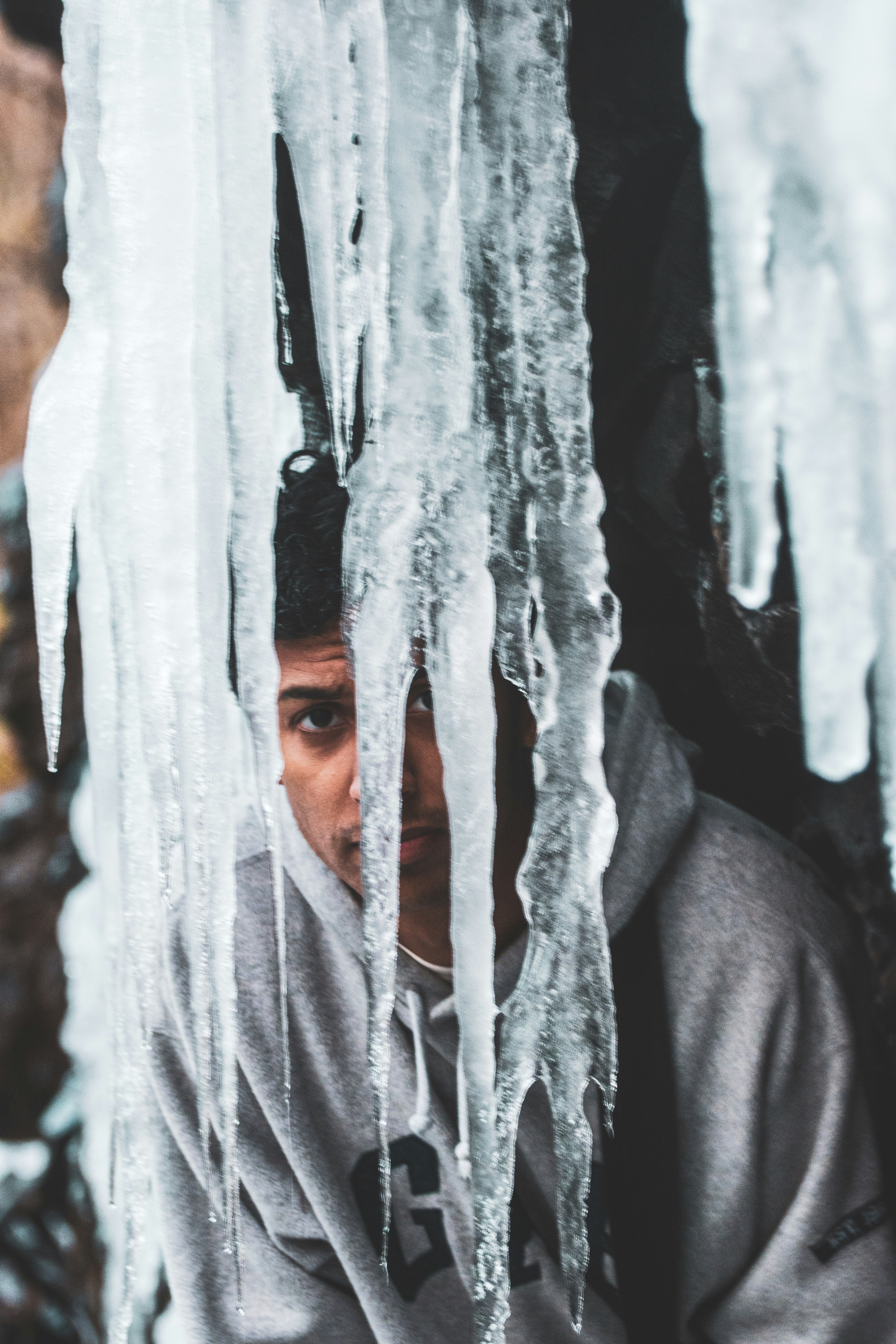 man wearing grey pullover hoodie behind ice